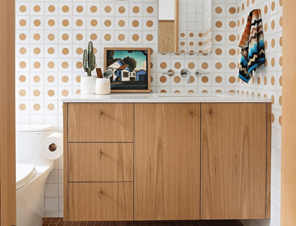 Contemporary floating vanity in natural white oak with wall-mount chrome fixtures and mosaic dot tile wall, Irvine