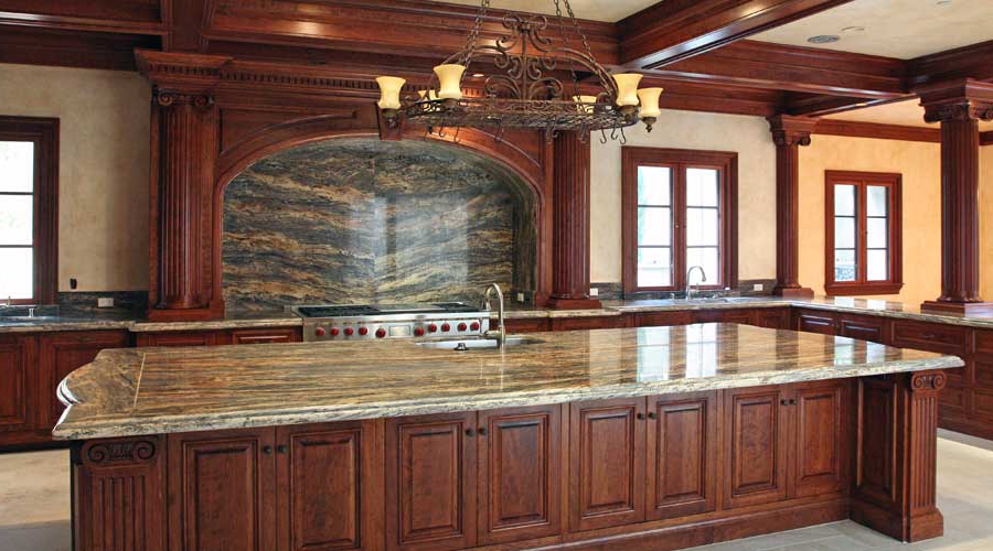 Grand traditional kitchen with dark cherry cabinetry, coffered ceiling, and arched range hood, Laguna Beach