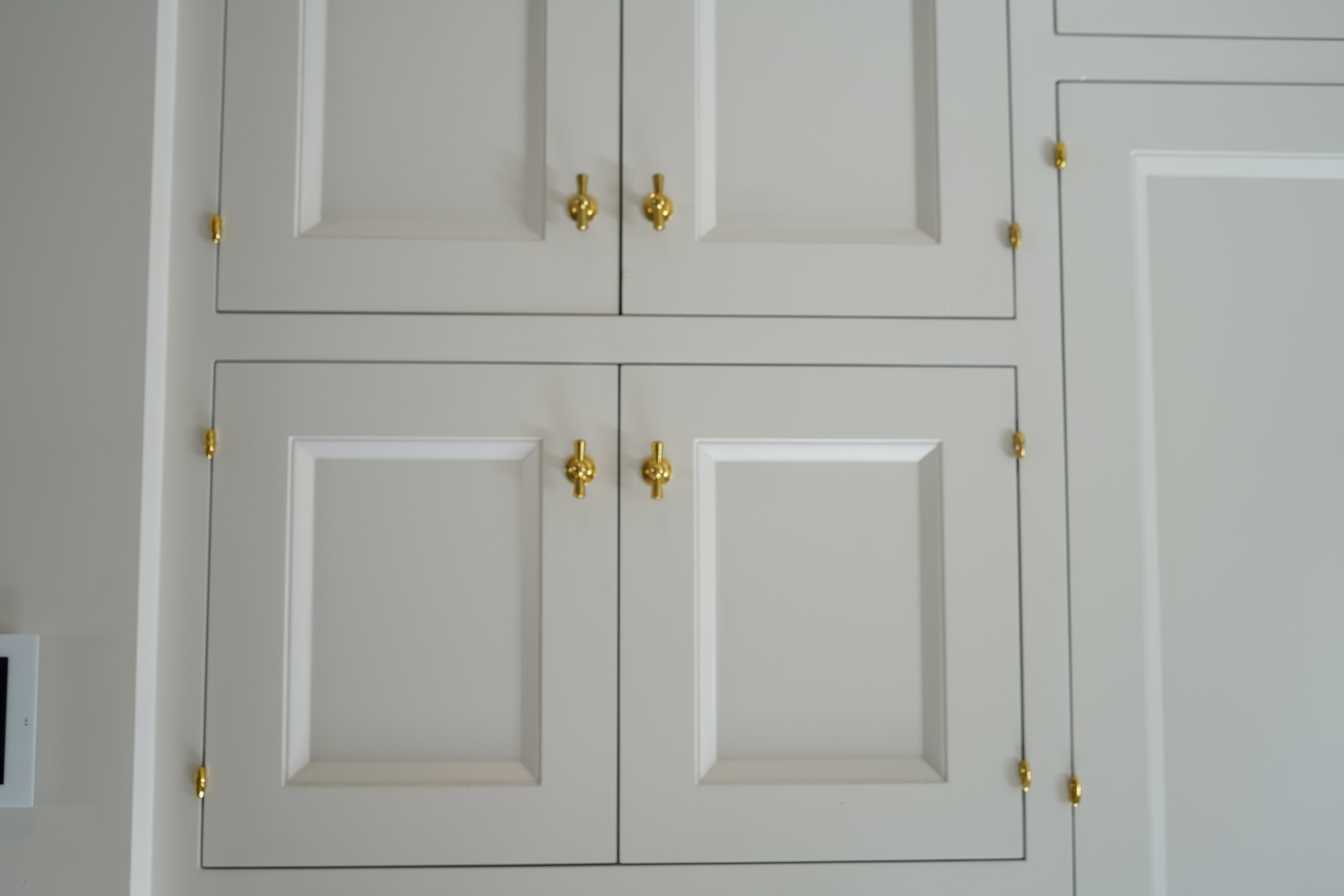 Custom white kitchen cabinet panel brass hardware close-up