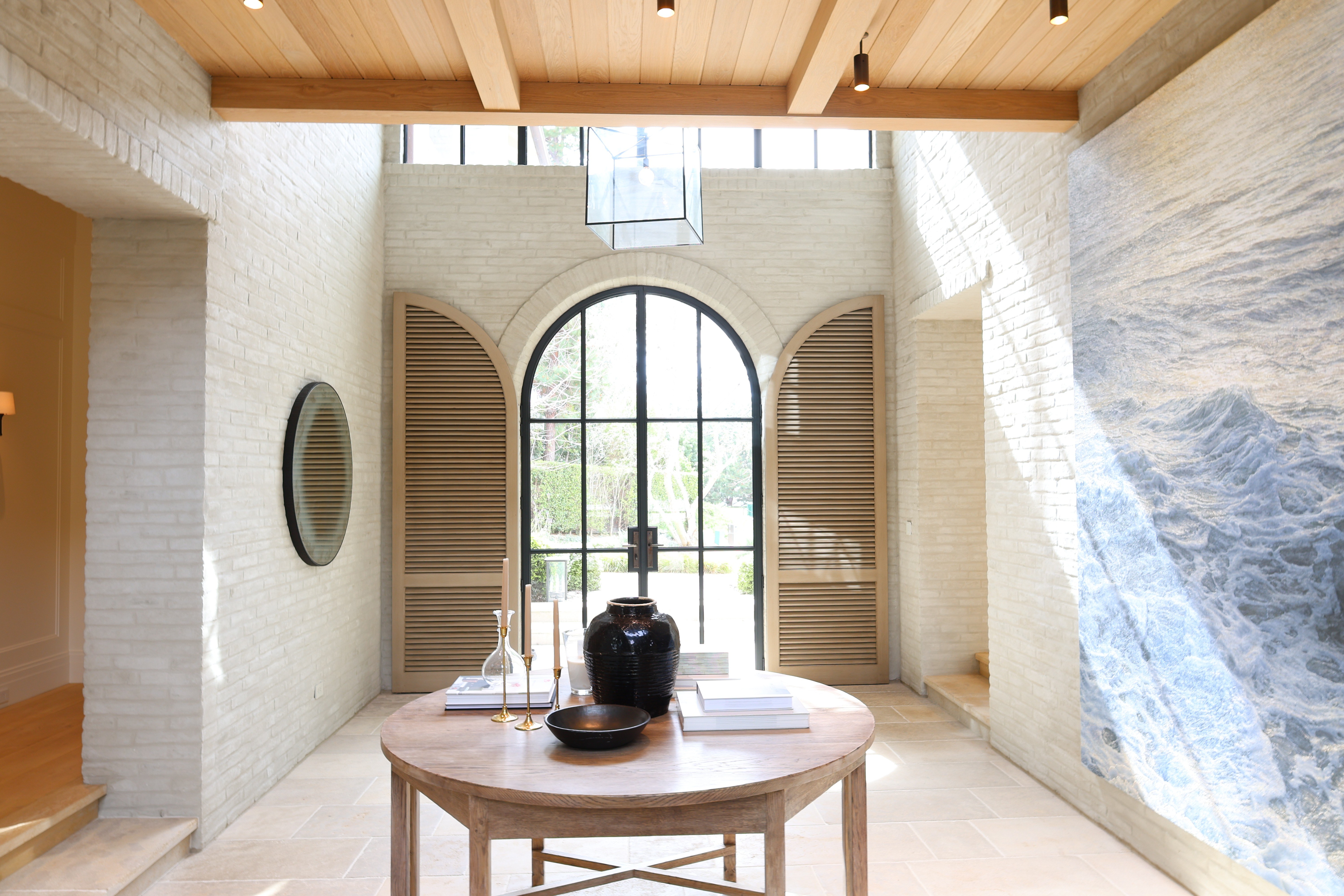 Custom arched wood louvered panel doors entry hall luxury home