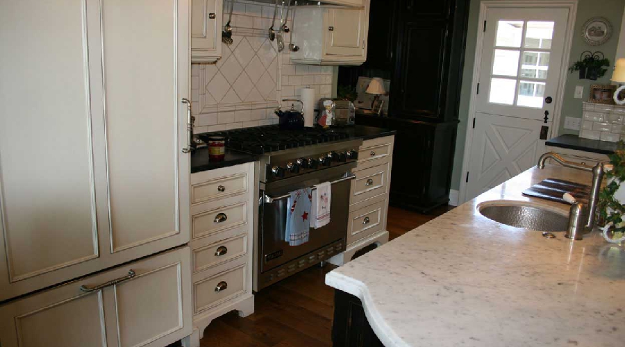 Antique-inspired custom cabinetry with multi-layer antiqued finish and detailed moulding, Laguna Beach